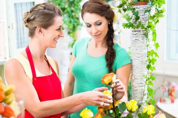 Blumenhändlerin verkauft Rosenstrauß an ihre Kundin — Stockfoto