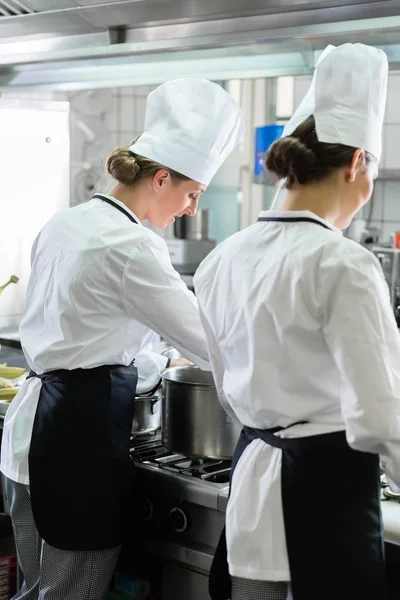 Chefs femeninos trabajando en cocina industrial —  Fotos de Stock