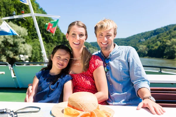 Famiglia seduta felicemente in barca sulla crociera sul fiume in estate — Foto Stock