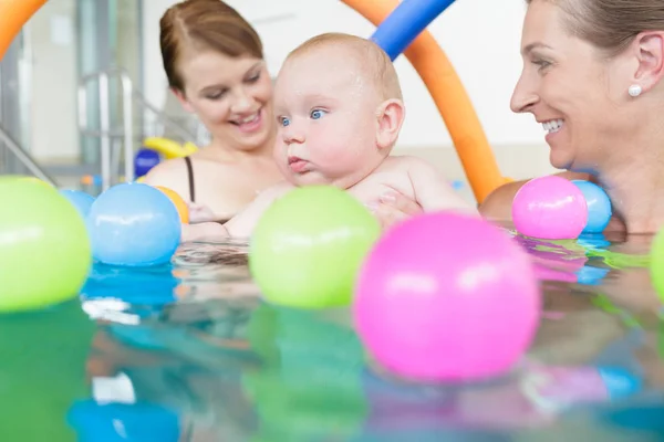 Mães e bebês se divertindo no curso de natação infantil — Fotografia de Stock