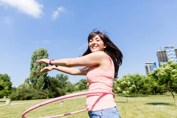 Mulher com hula hoop no parque no verão — Fotografia de Stock