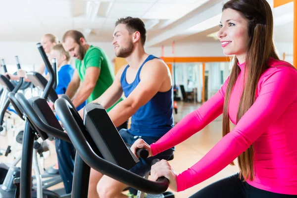 男性和女性在健身房有氧运动自行车上 — 图库照片