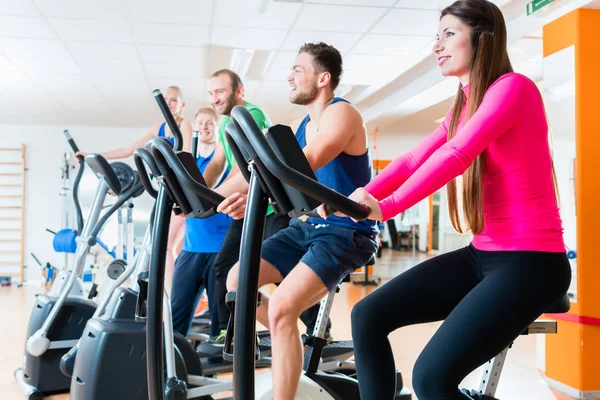 男性和女性在健身房有氧运动自行车上 — 图库照片