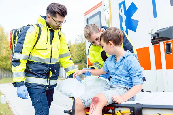 Emergency doctors caring for accident victim boy — Stock Photo, Image