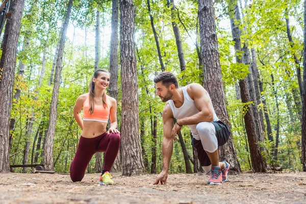 Homem e mulher se aquecendo e se alongando antes do exercício — Fotografia de Stock