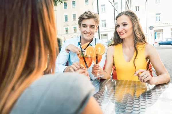 Feliz pareja brindando con su amiga mutua en un restaurante de moda — Foto de Stock