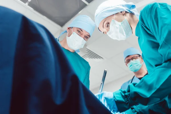 Equipe de cirurgiões na sala de cirurgia durante a cirurgia — Fotografia de Stock