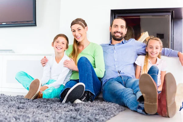 Familie zitten bij woonkamer vloer open haard — Stockfoto