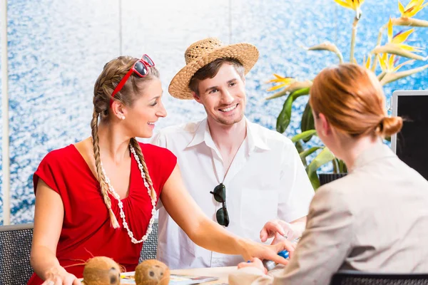 Paar im Reisebüro bucht Urlaubsreise — Stockfoto