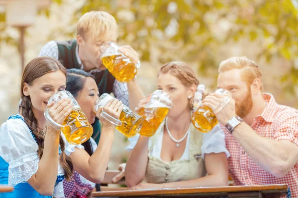 Friends drinking beer in beer garden — Stock Photo, Image