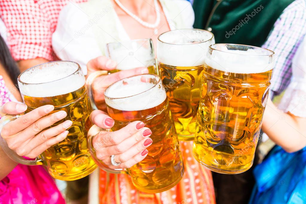Clinking glasses with beer in Bavarian beer garden