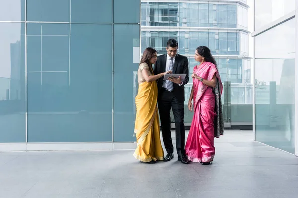 Three Indian business people using a tablet PC indoors — Stock Photo, Image