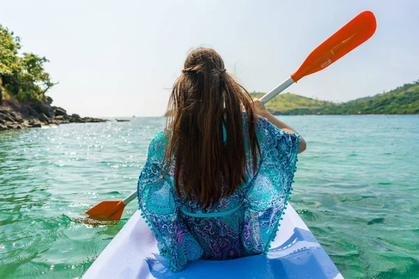 젊은 여자는 목가적인 섬의 해안을 따라 카누를 얕은 — 스톡 사진