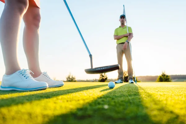 Golfball im selektiven Fokus unter dem Schläger einer Spielerin — Stockfoto