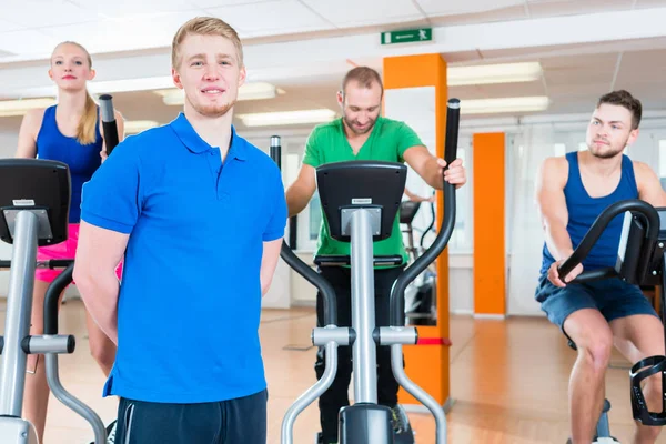 Physiotherapeut und seine Gruppe beim Spinning im Fitnessstudio — Stockfoto