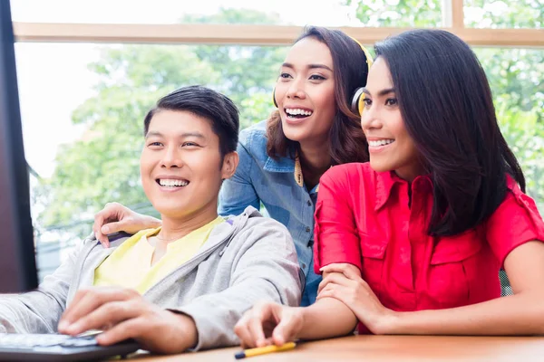 Tres colegas jóvenes y creativos trabajando juntos en un proyecto — Foto de Stock