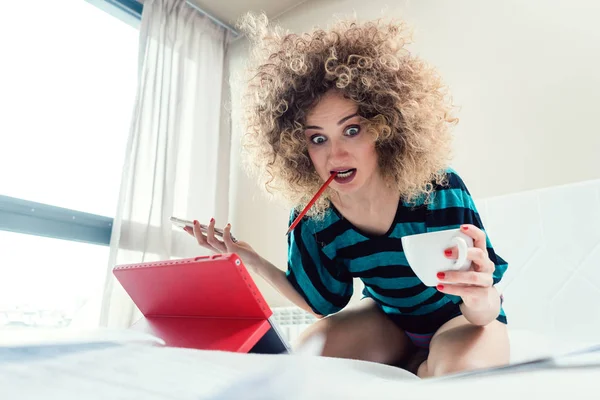 Woman student on her bed learning for exam in panic — Stock Photo, Image