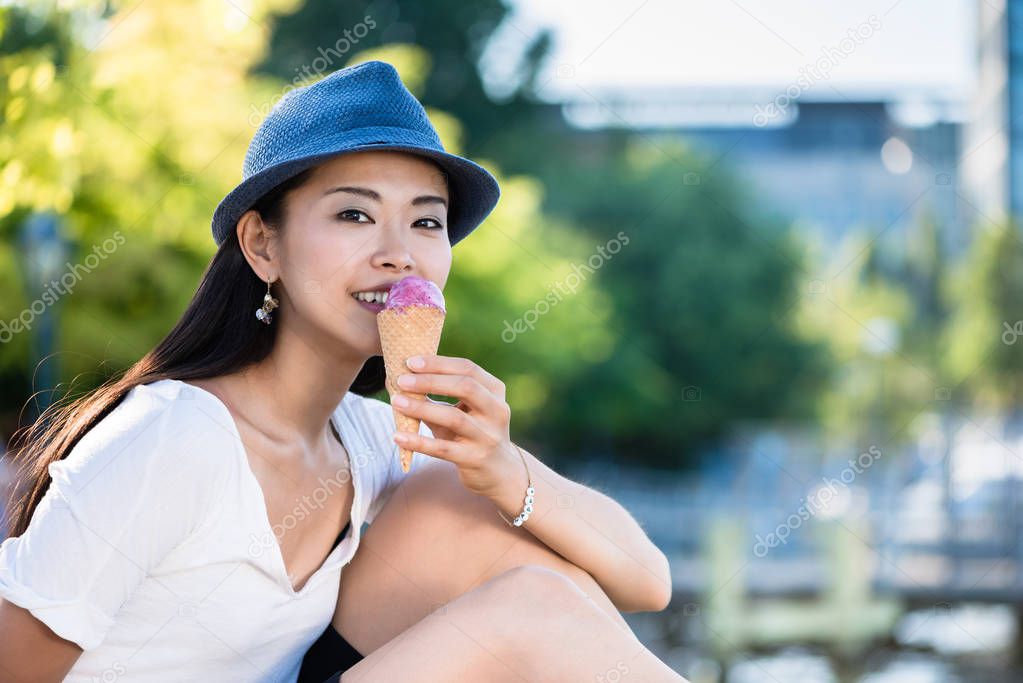 Young Japanese woman eating ice cream outdoors