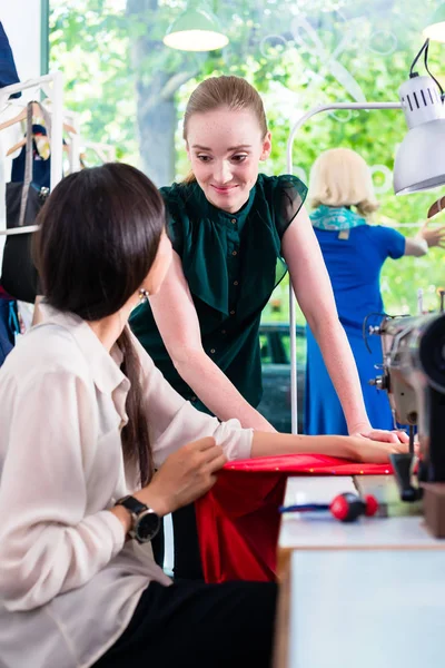 Diseñadoras de moda en conversación en su taller — Foto de Stock
