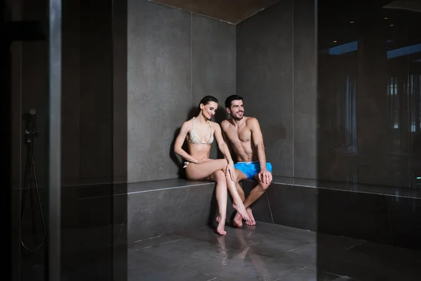 Pareja joven enamorada sentada en el baño de vapor de un moderno centro de spa — Foto de Stock