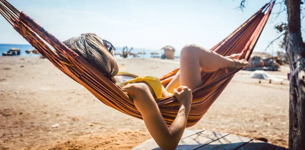 ビーチの近くにハンモックに横たわっている女性 — ストック写真