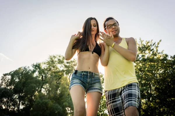 男は夏の公園で草の中で踊る女性を回し — ストック写真