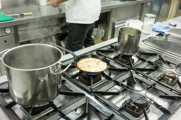 Apple pie in pan on stove in restaurant kitchen — Stock Photo, Image