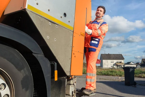 Vuilnis verwijdering werknemer rijden op de rug van het voertuig van de verwijdering — Stockfoto