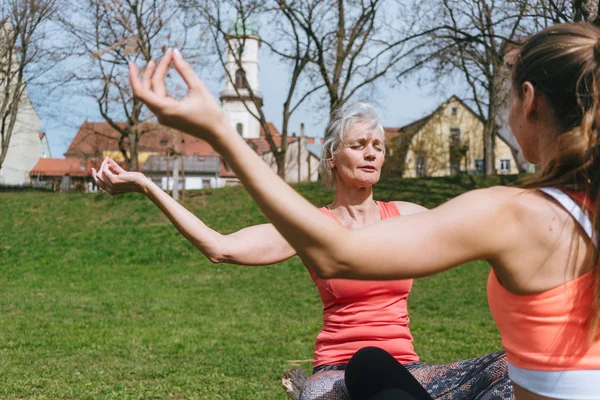 Madre e hija adulta en mediación de yoga al aire libre — Foto de Stock