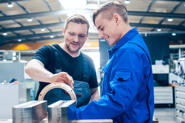 Meister diskutiert mit Lehrling oder Auszubildendem ein Werkstück — Stockfoto