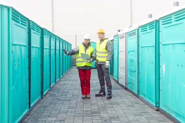 Рабочие проверяют переносные туалеты на прокат — стоковое фото