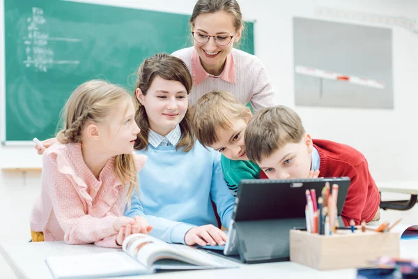 Profesores y estudiantes que utilizan medios y tecnología en el aula — Foto de Stock