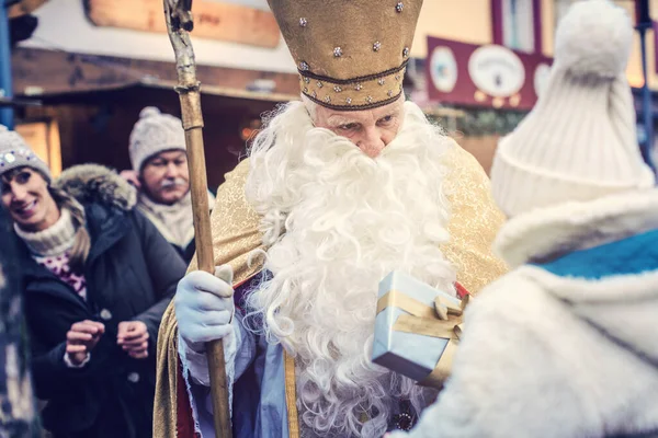 Святий Миколай і велика родина на Різдвяному ринку. — стокове фото