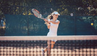 Kadın zorla tenis oynuyor.