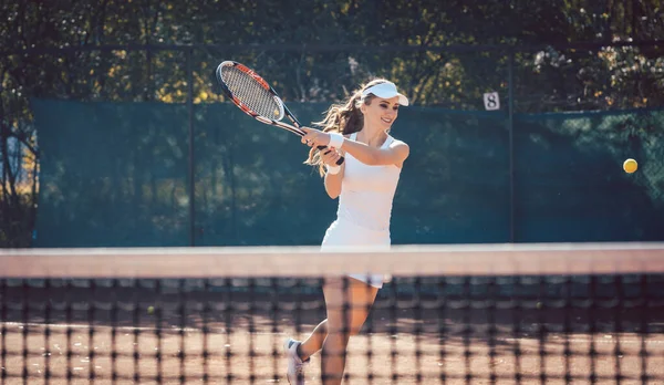 Femme jouant avec force au tennis — Photo