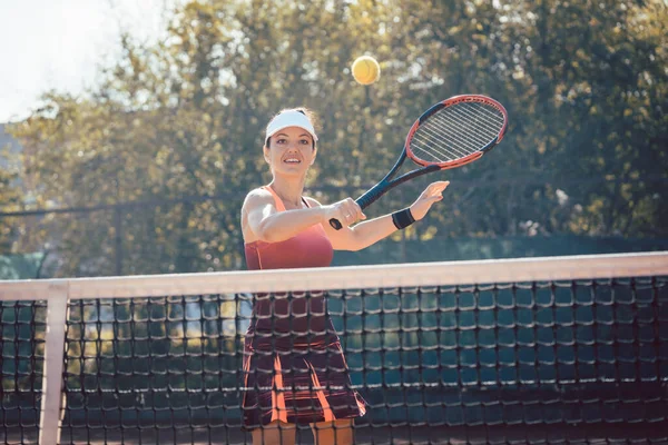 Mujer en vestido deportivo rojo jugando tenis —  Fotos de Stock