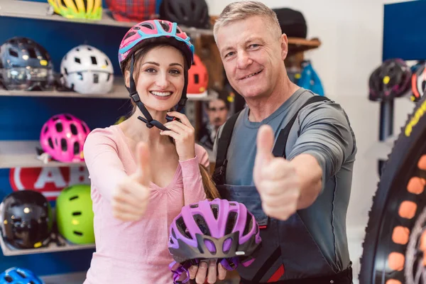 Cliente escolher capacete de bicicleta em uma loja — Fotografia de Stock