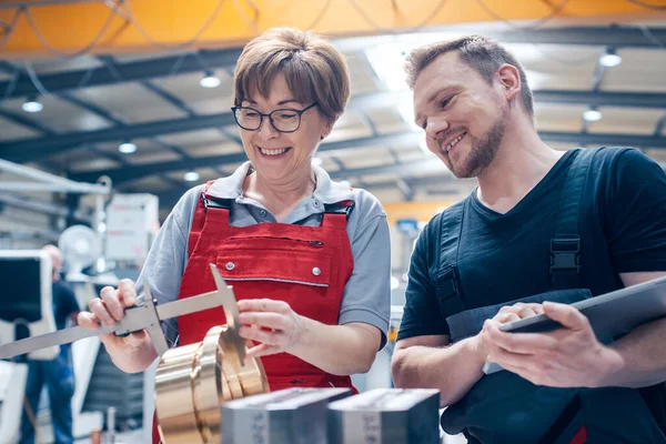 Arbeiter messen ein Metallwerkstück — Stockfoto