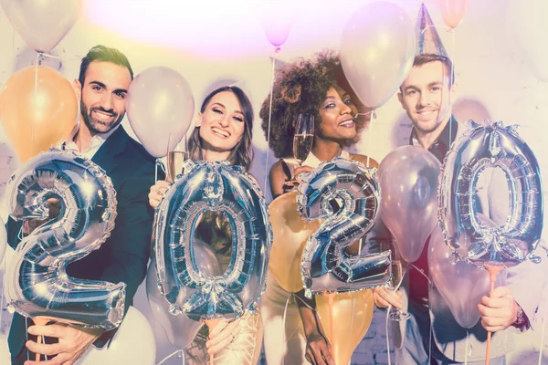 Imprezowicze kobiety i mężczyźni świętują Sylwestra 2020 — Zdjęcie stockowe