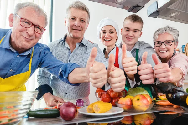 Εκπαιδευόμενοι και διατροφολόγος τους σε μια κουζίνα κατάρτισης δείχνει αντίχειρες — Φωτογραφία Αρχείου