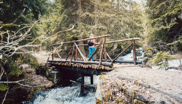 Mulher em uma caminhada de pé na ponte na floresta — Fotografia de Stock