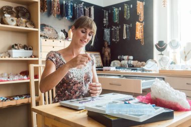 Hobi olarak mücevher kolye üzerinde çalışan bir kadın.