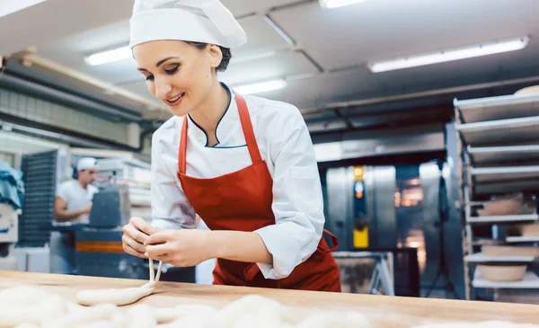 Baker donna formando pretzel e pane — Foto Stock