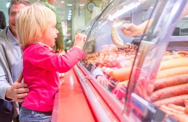 Anak di depan meja daging di supermarket — Stok Foto