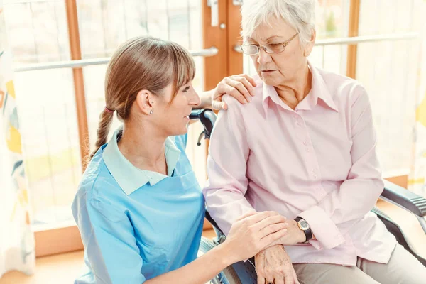 Vårdgivare och äldre kvinna på vårdhem — Stockfoto