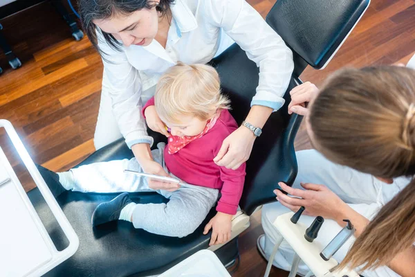 Klein kind kijken in spiegel wordt behandeld door de tandarts — Stockfoto