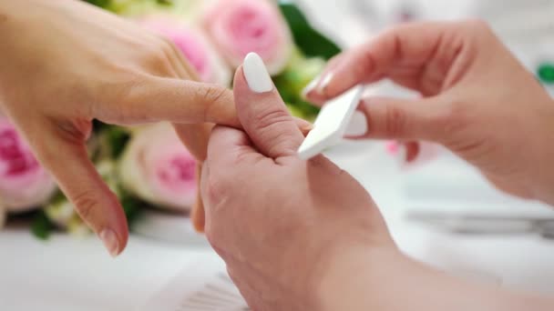 Close-up das mãos de uma manicure qualificada arquivando as unhas de uma mulher — Vídeo de Stock
