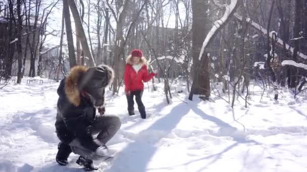 Frau wirft im Winter verspielt Schneeball auf ihren Mann — Stockvideo