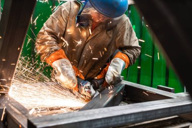 Açı öğütücü ile çalışan metal işçisi