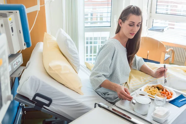 Paciente en el hospital acostado en cama comiendo comida — Foto de Stock